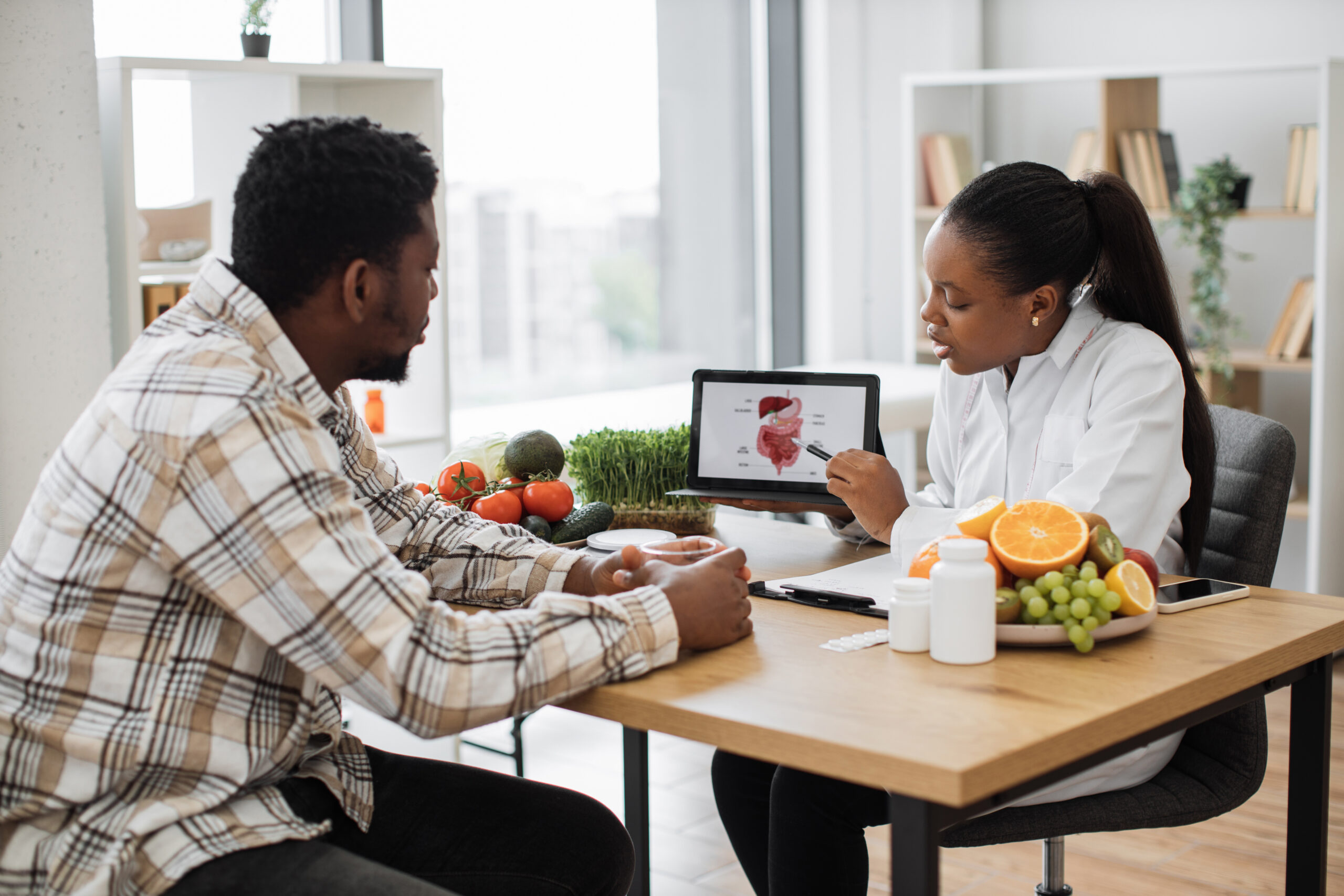 Food expert showing digestive system to client via tablet